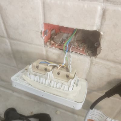 שקע חשמלי פתוח עם חוטים חשופים בקיר