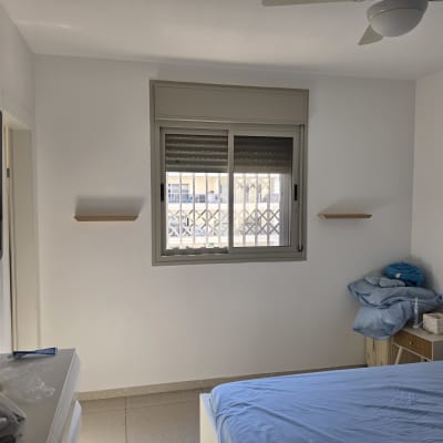 תליית טלוויזיה והתקנת מדפי עץ צפים בחדר שינה
