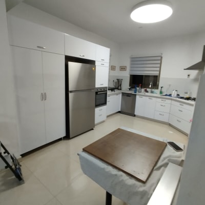 מטבח עם מקרר, תנור וכיור על השיש