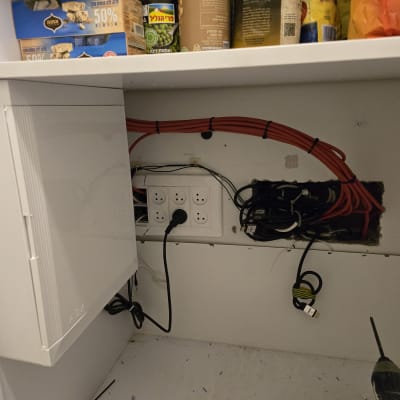 ארון תקשורת עם כבלים אדומים ושקעי חשמל