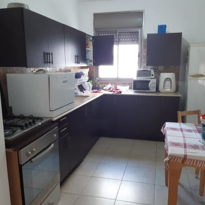 דלי צבע על שולחן במטבח עם ארונות כהים