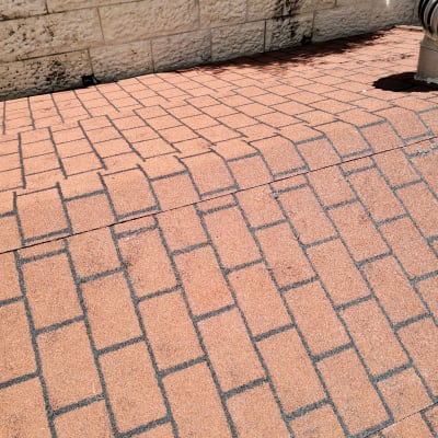 רצפת רעפים אדומה עם קיר אבן מאחור