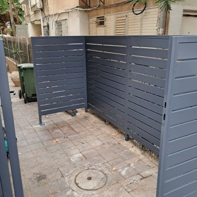 גדר מתכת אפורה מותקנת בחצר בניין
