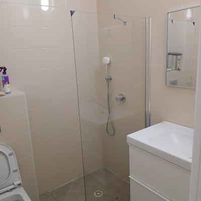 מקלחון זכוכית עם ראש מקלחת בחדר אמבטיה