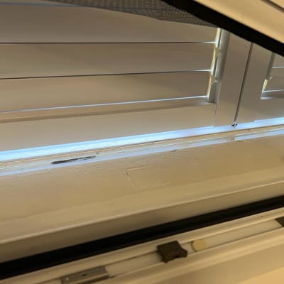 תריסים לבנים פתוחים עם חוט משיכה שחור