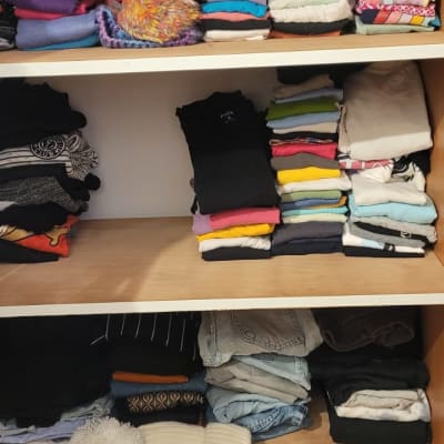 בגדים מקופלים בארון על מדפים שונים