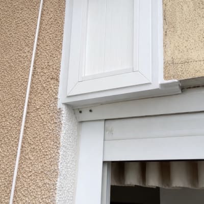 חלון אטום עם מסגרת לבנה על קיר חיצוני