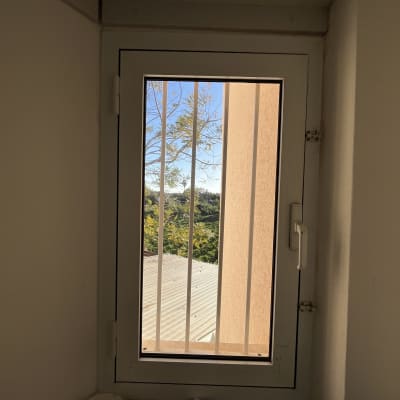 חלון עם סורגים ונייר טואלט על מדף