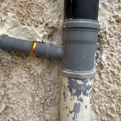 צינור פלסטיק מותקן בקיר עם חומר איטום