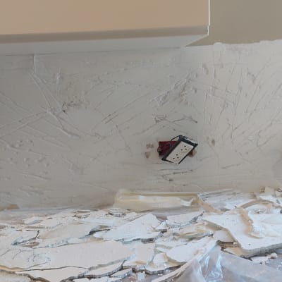 קיר עם טיח שבור ושקעים חשמליים חשופים