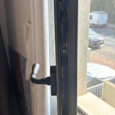 ידית חלון מתכתית על מסגרת תריס