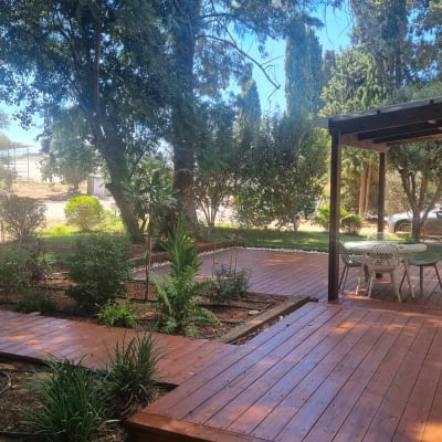 דק עץ בגינה עם שולחן וכיסאות