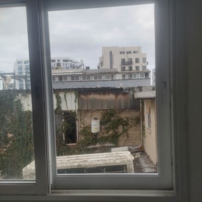 חלון אלומיניום עם נוף עירוני ברקע