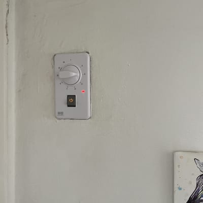תרמוסטט על קיר עם כפתור הפעלה מואר