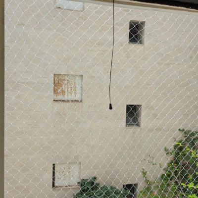 רשת מתכת מותקנת על חלון למניעת כניסת יונים
