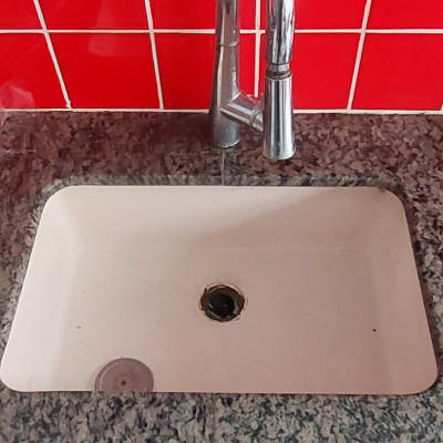 כיור משיש עם ברז מתכת וקיר אריחים אדומים