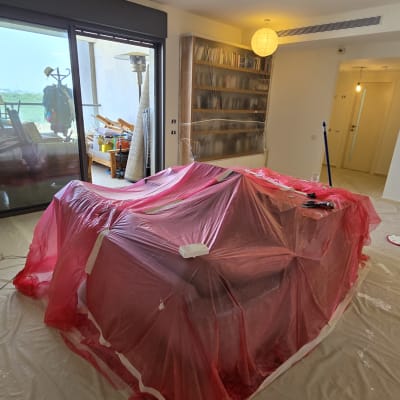 חדר עם רהיטים מכוסים בניילון לצביעת קירות