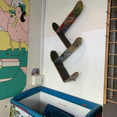 קרש סקייטבורד משומש תלוי על קיר לבן