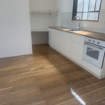 רצפת פרקט מבריקה במטבח מודרני עם ארונות לבנים