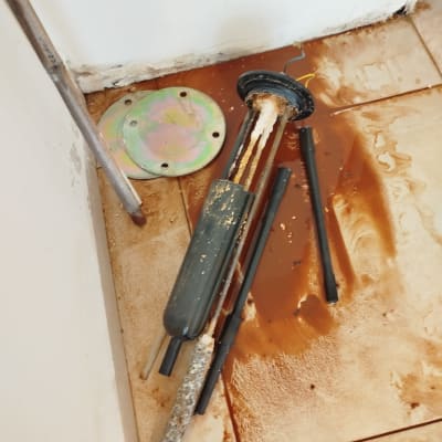 חלקי דוד שמש מפורקים על רצפה מלוכלכת