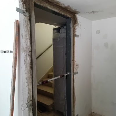 תיקוני טיח ושפכטל סביב משקוף דלת במהלך עבודות תיקון