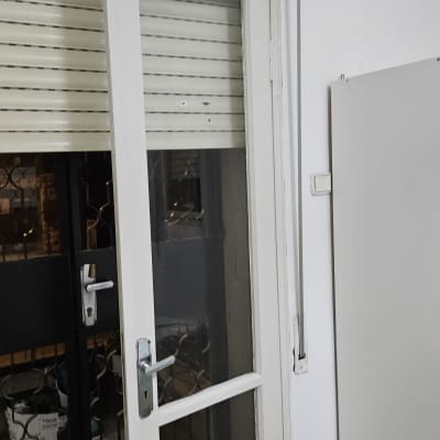 תריס גלילה לבן מעל דלת זכוכית