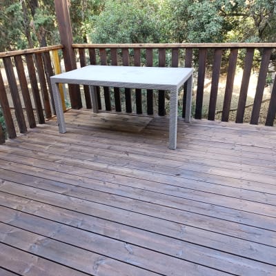 מרפסת עץ עם שולחן חיצוני על רצפת דק