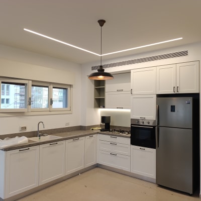 מטבח מודרני עם ארונות לבנים ומכשירי חשמל