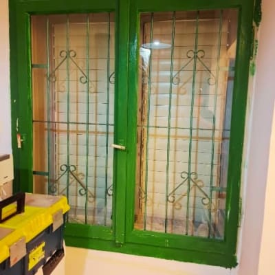 חלון עם מסגרת ירוקה וסורגים