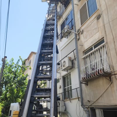 מנוף משאית ליד בניין מגורים