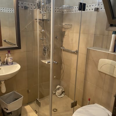 מקלחון זכוכית עם ראשי מקלחת וכיור בחדר אמבטיה