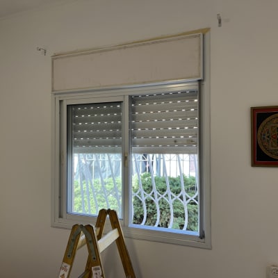 חלון עם תריסים וסולם בחדר