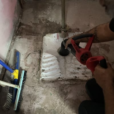 אדם משתמש בכלי אינסטלציה לפתיחת סתימה