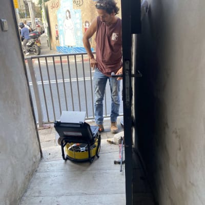 אדם עם ציוד בדיקת נזילות בכניסה לבית