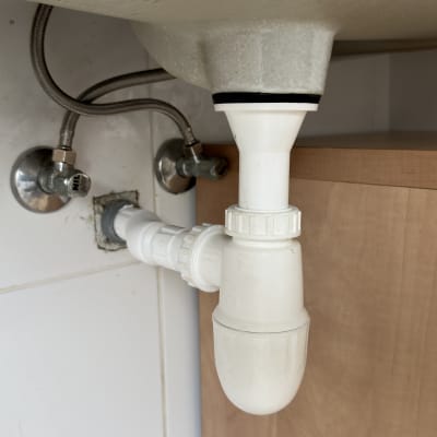 צנרת פלסטיק מתחת לכיור עם ברזים