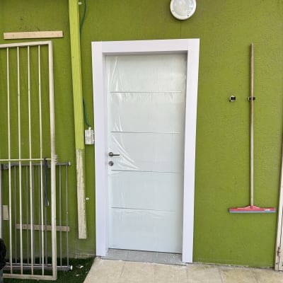 דלת לבנה עם מסגרת על קיר ירוק