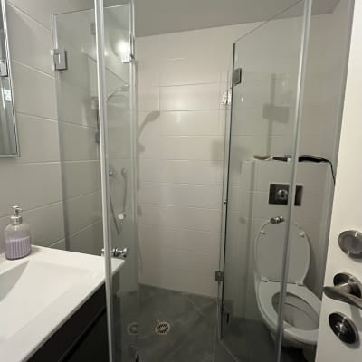 מקלחון זכוכית בחדר אמבטיה עם כיור ושירותים