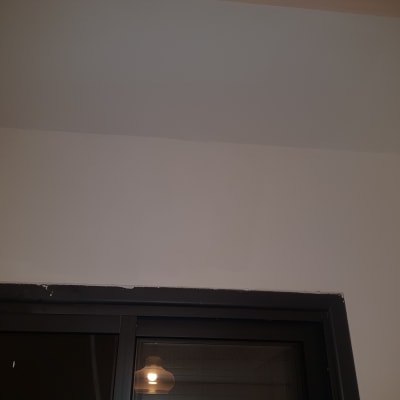 קיר לבן עם חלון שחור ותאורה פנימית