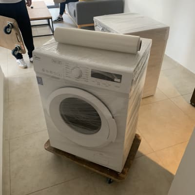 מכונת כביסה עטופה בניילון על עגלה ניידת