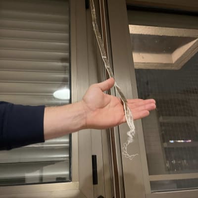 יד מחזיקה חבל תריס ליד חלון