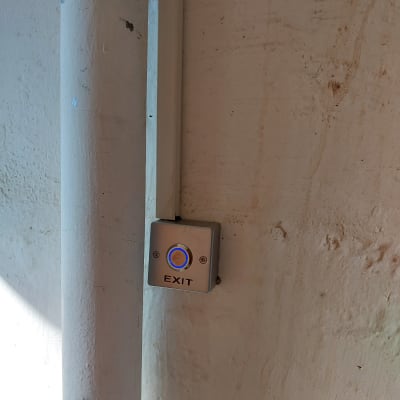 לחצן יציאה עם תאורה כחולה על קיר