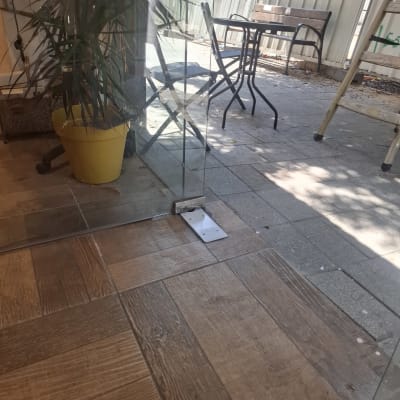 דלת זכוכית ליד עציץ וכיסאות בחוץ