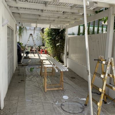 סולם צהוב, קרשים לבנים, יריעת פלסטיק על הרצפה