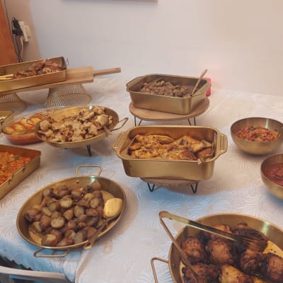 מגוון מנות חמות בכלי הגשה על שולחן לבן