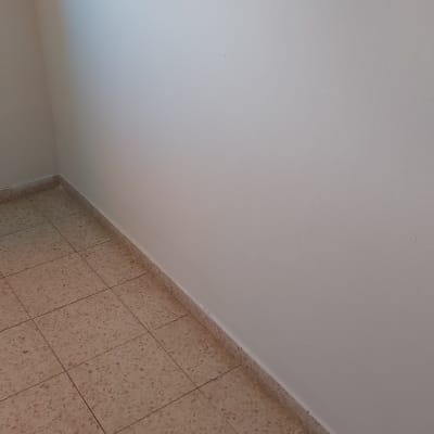 קיר צבוע בלבן עם רצפת אריחים