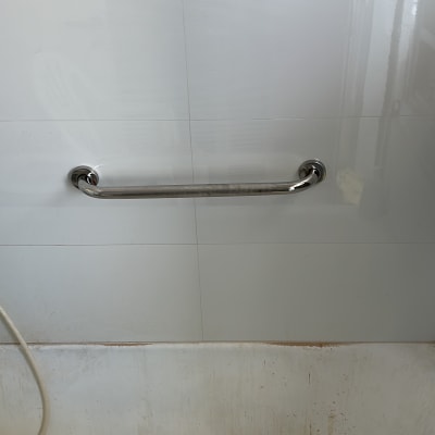 ידית אחיזה מותקנת על קיר אריחים בחדר אמבטיה