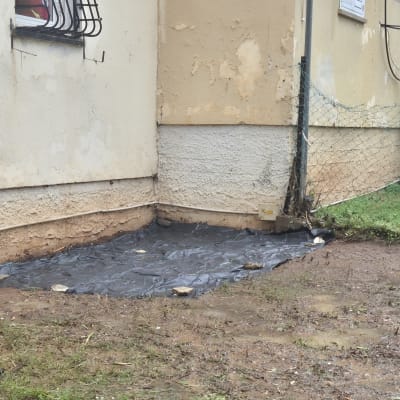 שטח עם יריעת פלסטיק ליד קיר בניין