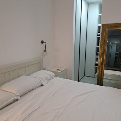 חדר שינה מסודר עם מיטה, שידה וארון בגדים