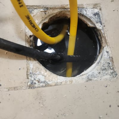 צינורות צהובים ושחורים בתוך חור עם מים