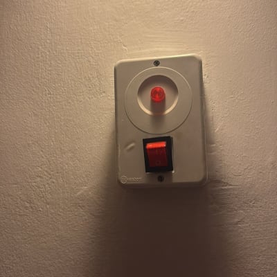 מתג חשמלי עם נורית חיווי על קיר